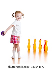 Kid Girl Throwing Ball To Knock Down Toy Bowling Pins. Focus On Child.