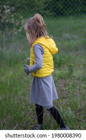 Kid Girl Walking By Grass At Backyard And Wearing Clothes Of Trendy Color Of The Year 2021 - Illuminating Yellow And Ultimate Gray