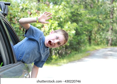 A Kid Going Crazy Out A Window Of A Car