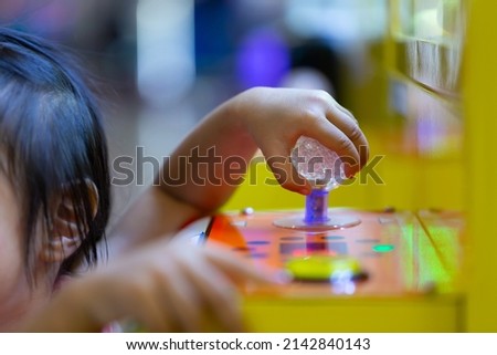 The kid hand is controlling the arcade of the doll.