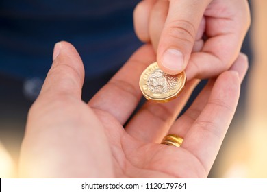 Kid Hand Giving One Pound Coin To His Teacher For Donate To Poor Children,Crop View Of Children Hand Giving Money Coin To Another Person,Children Learning About Sharing And Giving And Donation Concept