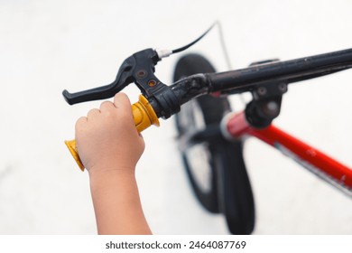 Kid hand holding bicycle steering wheel closeup top view - Powered by Shutterstock