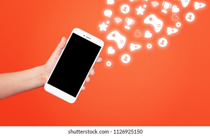 Kid Hand Holding Phone Surrounded With Award And Achievement Icons On Red Background. Gamification Concept