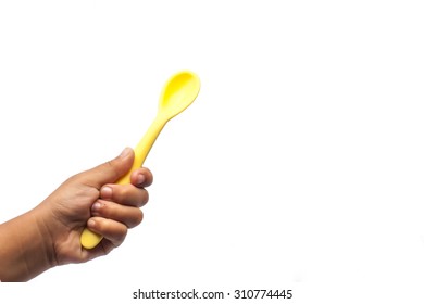 Kid Hand Holding Yellow Baby Spoon