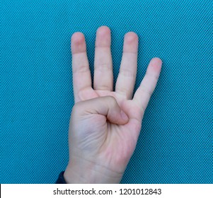 Kid Hand Showing Four Fingers On Blue Background,Selective Focus Of Kid Primary School Counting Number 4,Children Showing Number Four On Finger,victory Sign,Education Or Toddler Development Concept