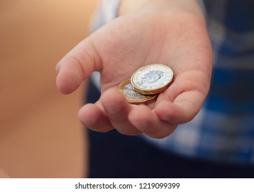 Kid Hand Showing Money Two Pound Coins On His Hands,Child Holding New British One Pound On Both Hands, New Pound Coin, 2017 Design