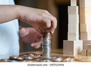 Kid Hand Stacking Sterling Pound Coin And Pennies Nickels On Wooden Table With Copy Space, Financial Planing For New Year Resolution Or Saving Money For Business Or Life In Future