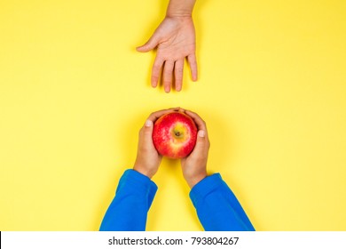 Kid Hand Taking Red Apple From Another Child's Hands