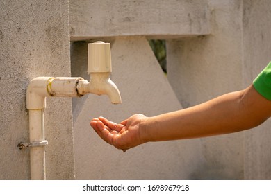 Kid Hand Wait For Water Drop To Drink From Fiber Pipe Line Tap On White Background. Water Shortage And Earth Day Concept, Concept Of Forecasts Of Earth's Water Crisis, Kids Hand