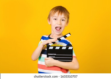 Kid Hands Holding Clapper Board For Making Video Cinema In Studio.Movie Production Clapper Board Or Slate Film Concept. Kids Hobbies And Leisure. Little Producer Making Film