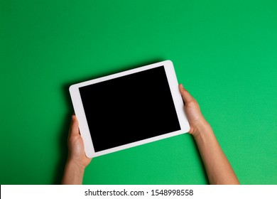 Kid Hands Holding White Tablet Computer On Green Background