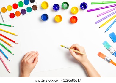 Kid Hands Painting At The Table With Art Supplies, Top View