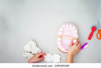 Kid Hands Play On Doh Clay In Dentist ,teeth And Tools On Floor