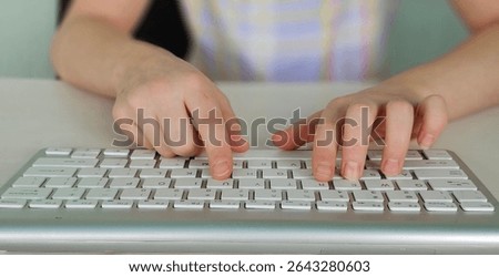 Kid hands use computer keyboard. Child Hands typing on the pc keyboard.