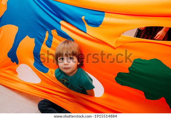 Kid has\
fun at entertaining center. Orange\
background