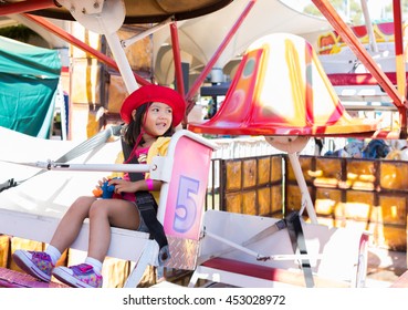 Kid Has A Good Time And Smile On Ferris Wheel On Sunny Day