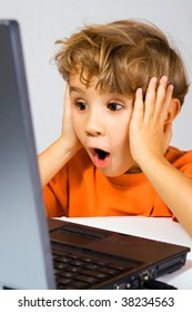 The Kid Has Opened A Mouth From Surprise, Looking At The Laptop Screen