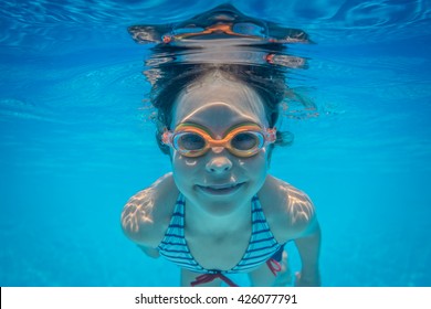 Kid Having Fun In Swimming Pool. Underwater Portrait Of Child. Summer Vacation