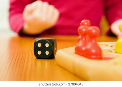 Kid Having A Good Hand Rolling The Dice During A Board Game