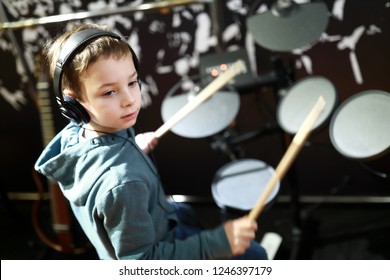 Kid With Headphones Playing Drums In Music Class