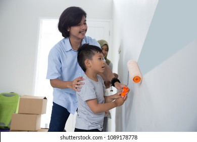 Kid Helping His Daddy To Pain The Wall In Their New House