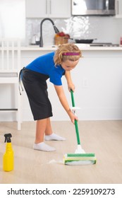 Kid helping with housework, cleaning. Children helping with housekeeping, cleaning the house. Housekeeping at home. Cute child boy helping with housekeeping on kitchen interior backdround. - Shutterstock ID 2259109273
