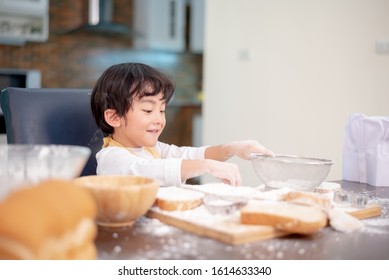 Kid Helping Mom For Cooking For Valentine's Day. Preparing An Ingredient With Powder And Flour. Dirty And Messy Kitchen.