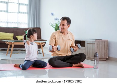 Kid And His Dad Doing Exercise Weight Lifting At Home Together