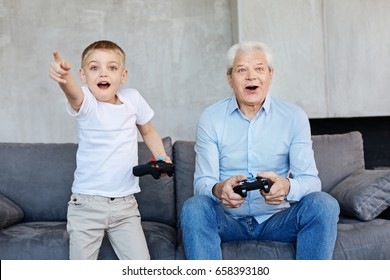 Kid And His Grandpa Playing Video Games Together