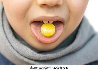 Kid Hold On Tongue Anaesthetic Sore Throat Lozenges For Pain Redness Irritation Treatment.isolated On White Child With Scarf Around Neck.sweet Candy Yellow Color Lemon Honey Ingredients.wide Banner