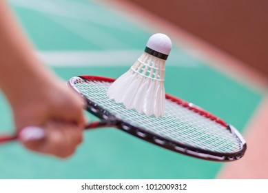 kid holding badminton racket and shuttlecock  in badminton court.