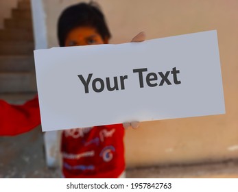 Kid Holding Blank Paper Mockup In Hand And Showing With Copy Space And Selective Focus