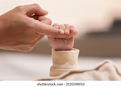 Kid is holding mom's finger that make him feel safe and secure. Strong relationship in family make children feel loved and confidence. The root for raised a good person is started from parenthood. - Shutterstock ID 2135598933