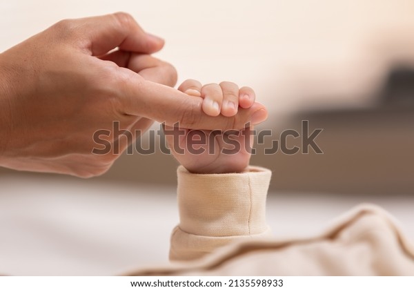 Kid is holding mom\'s finger that make him\
feel safe and secure. Strong relationship in family make children\
feel loved and confidence. The root for raised a good person is\
started from parenthood.