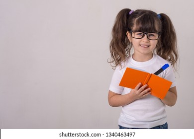 Kid Holding Notepad And Taking Notes. Space For Advertisement.