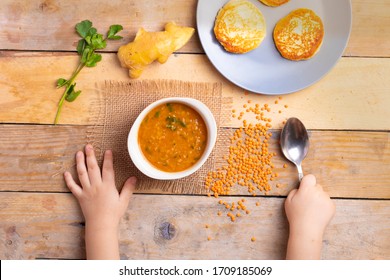 Kid Holding Spoon, Vegan Lentil Cream-soup And Ginger With Parsley. Flay Lay. Vegan Meal Concept