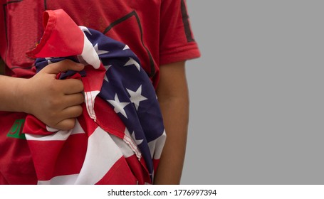 Kid Holding USA Flag In Hand Close To His Body - 4th Of July Concept