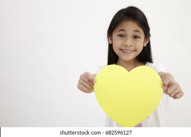 Kid Holding Yellow Heart Shaped Card On The White Background