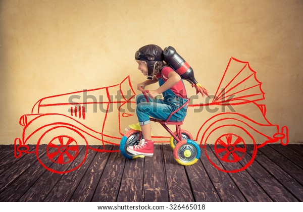 Kid with jet pack riding bike. Child\
playing at home. Success, leader and winner\
concept