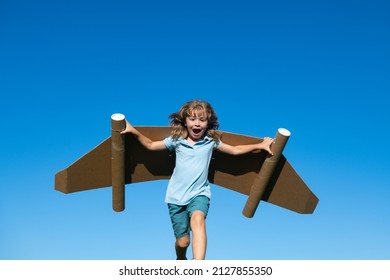 Kid With Jet Pack Superhero. Child Pilot Against Summer Sky Background. Boy With Paper Plane Flight, Toy Airplane With Cardboard Wings, Imagination, Kids Freedom.