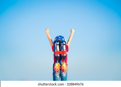 Kid with jetpack against blue sky. Child playing outdoors. Success, leader and winner concept