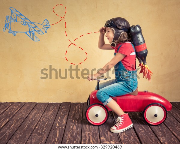 Kid with jetpack driving retro\
toy car. Child playing at home. Success, leader and winner\
concept