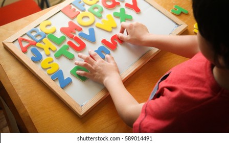 kid is Learning the alphabets at home.