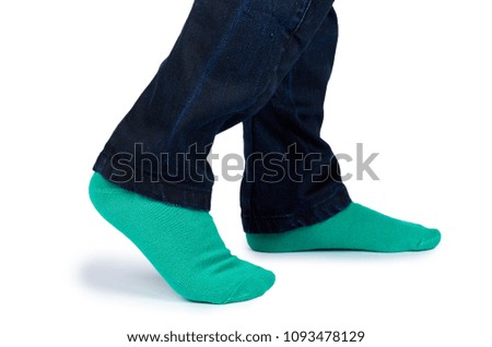 Kid legs in colored socks on leg isolated on white background.
