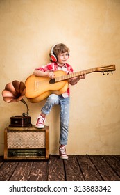 Kid Listen Music At Home. Hipster Child With Retro Vintage Acoustic Guitar