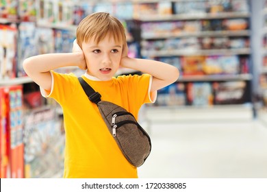 Kid Makes Difficult Choice In Supermarket. ?hildren's Tantrum In The Store. Boy Can't Selecting Toy In Kids Store. Shop Toys. Inside Toy Shop. Little Boy Getting Hysterical In Toy Shop.