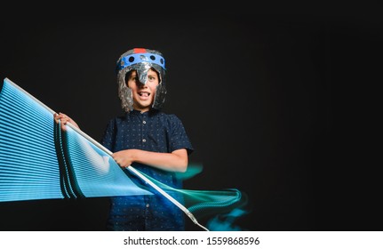 The Kid With A Makeshift Helmet And With A Neon Lamp In His Hands, As If With A Lightsaber, Emotionally Depicts The Battle Of A Superhero.