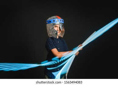 The Kid With A Makeshift Helmet And With A Neon Lamp In His Hands, As If With A Lightsaber, Emotionally Depicts The Battle Of A Superhero.