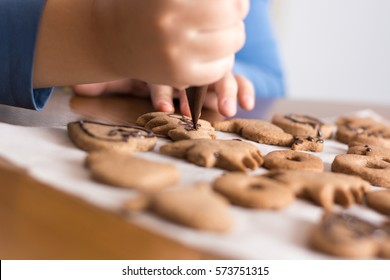 Kid Making Decoration On Gingerbread Cookie; Baking With Children