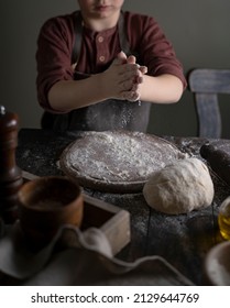 Kid Making Dough On Wooden Table With Ingredients Flour, Oil, Salt, Dark Background. Copy Space. Home Bakery Concept, Kitchen Cooking Story.